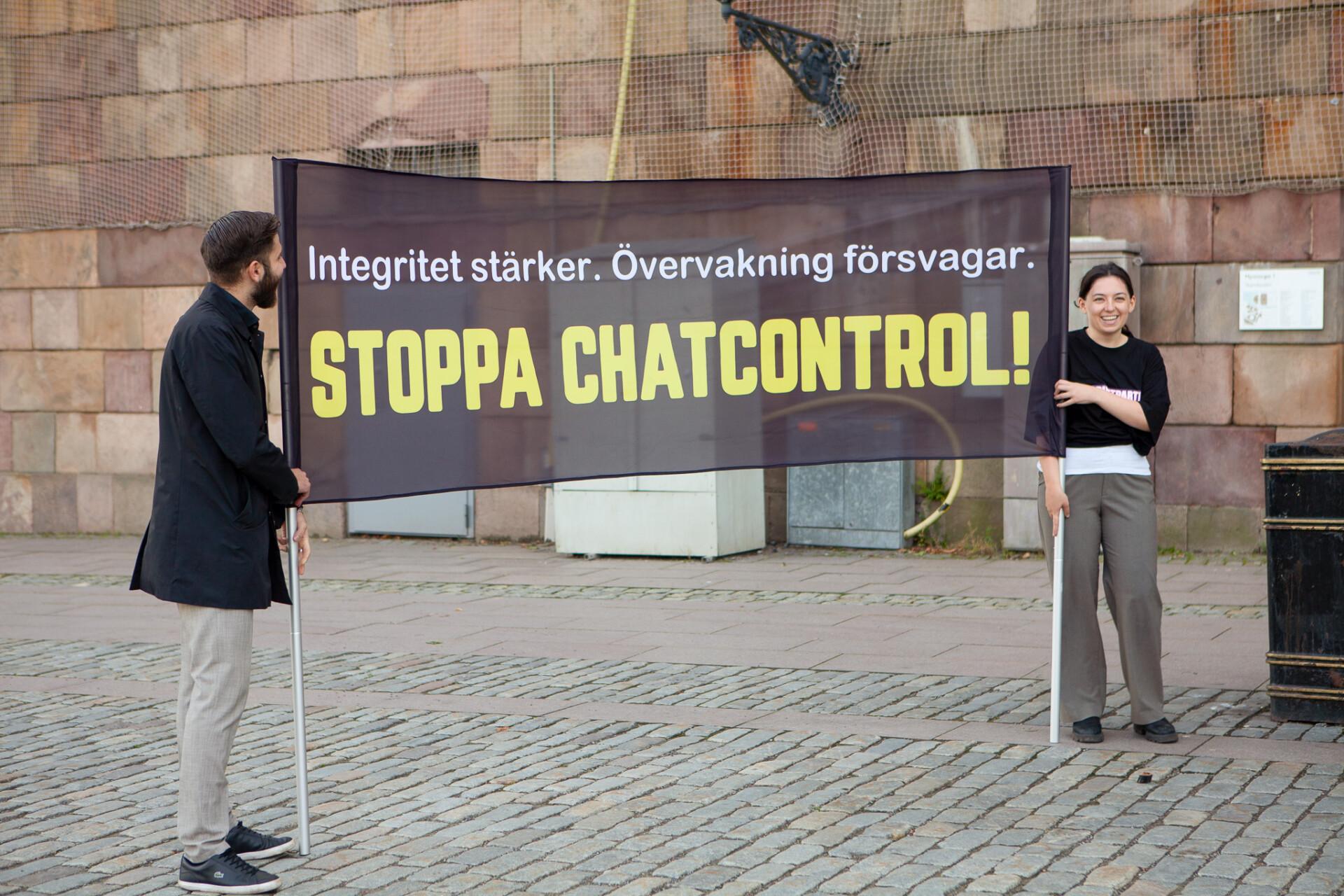 Ung Pirat håller upp en banderoll med texten Stoppa Chat Control.